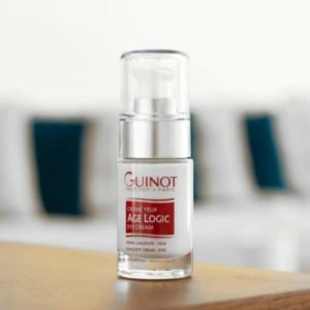 Flacone di siero con dosatore su un tavolo. Scritta: Guinot, Age Logic, Eye Cream. Sfondo sfocato.