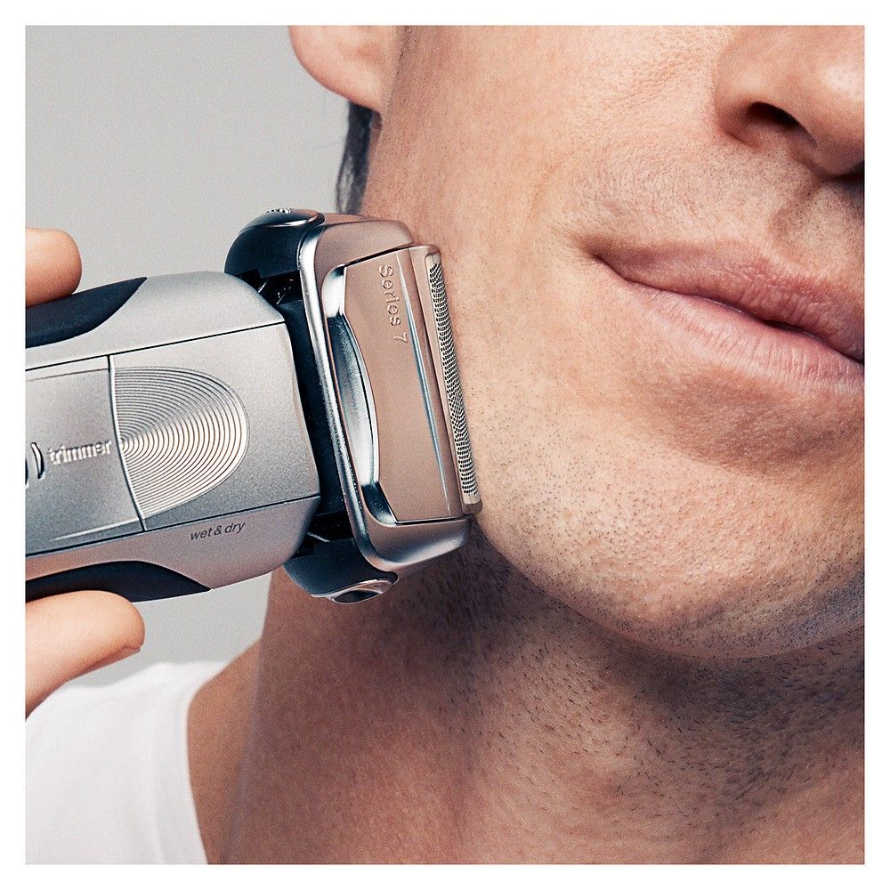 Uomo che si rade con rasoio elettrico Braun Series 7. Primo piano del viso.