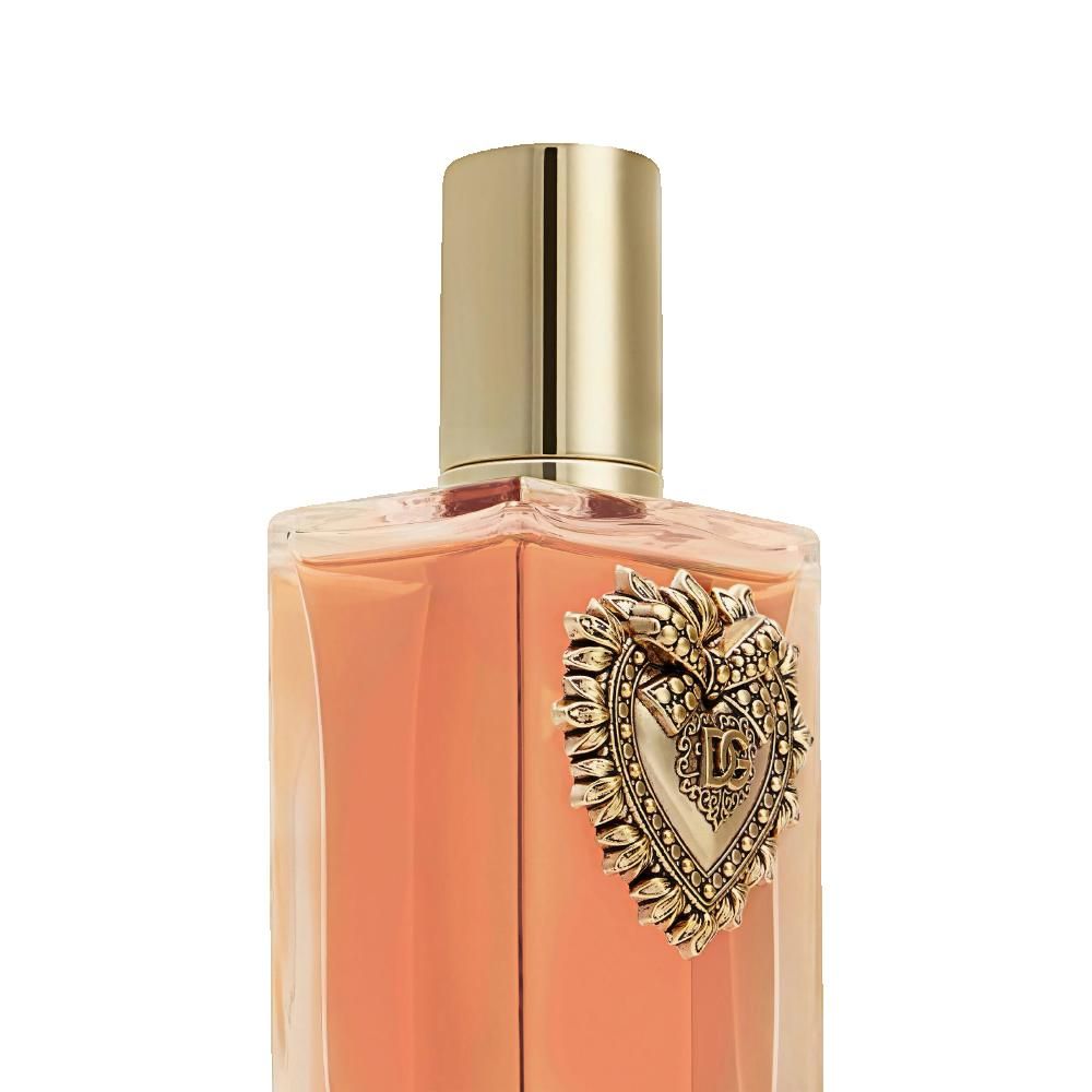 Flacone di profumo con tappo dorato ed emblema a forma di cuore. Liquido rosa visibile.