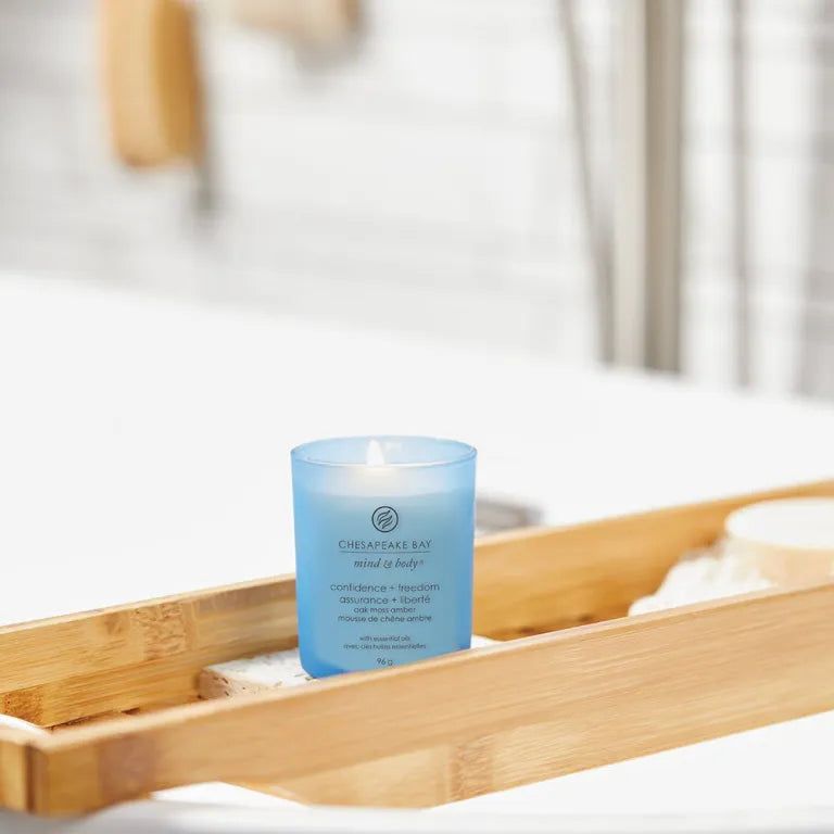 Candela blu Chesapeake Bay, Confiance + liberté, su vassoio in legno in bagno. Scritta Mind & Body.