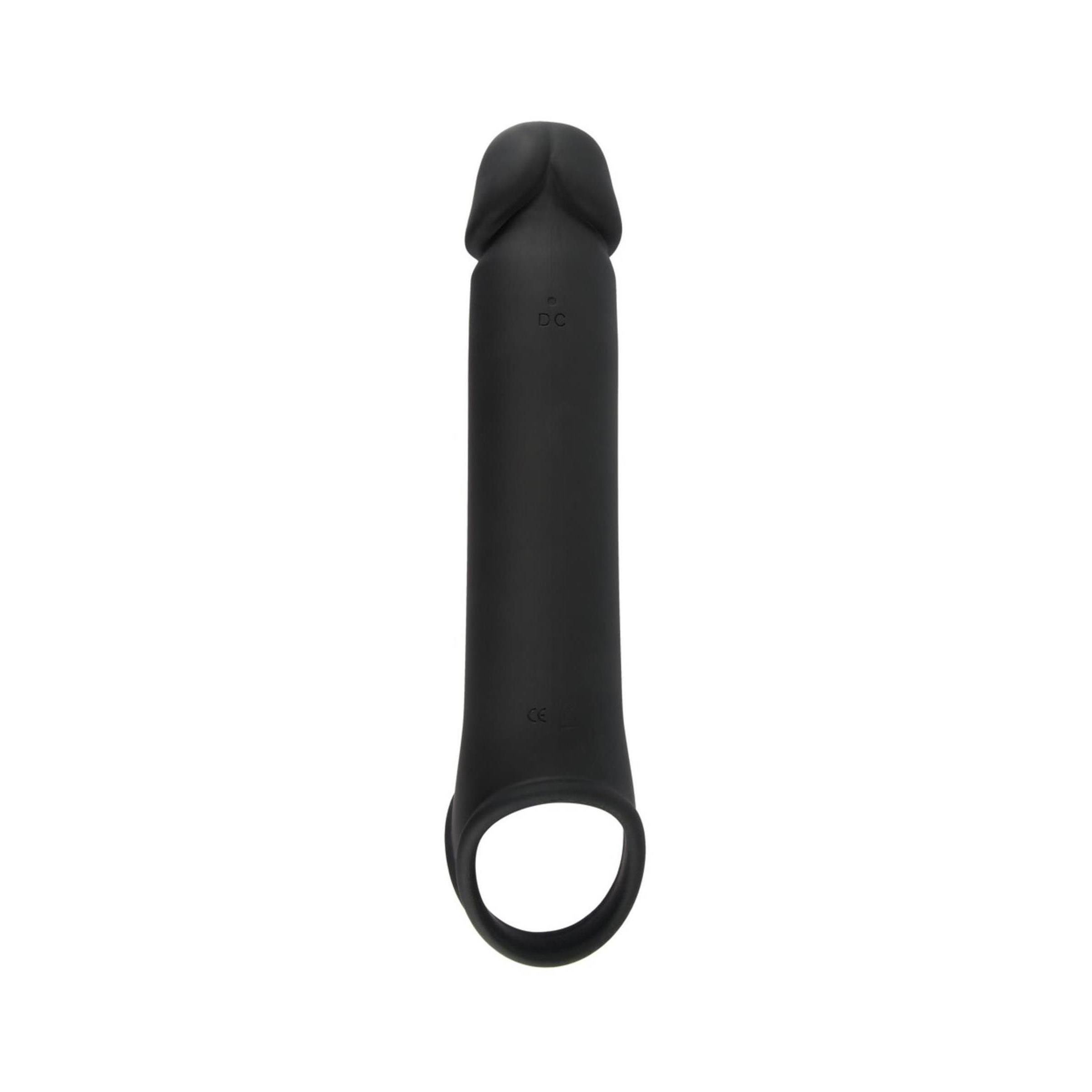 Rivestimento per pene nero con anello per le palle. Il rivestimento è di forma allungata con un anello all'estremità. Un pulsante è visibile.