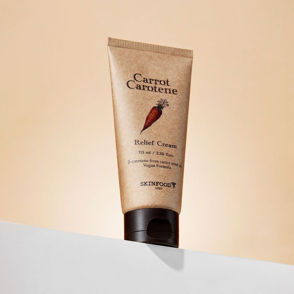 Tubo beige con tappo marrone su superficie bianca. Scritta: Carrot Carotene, Relief Cream, SKINFOOD.