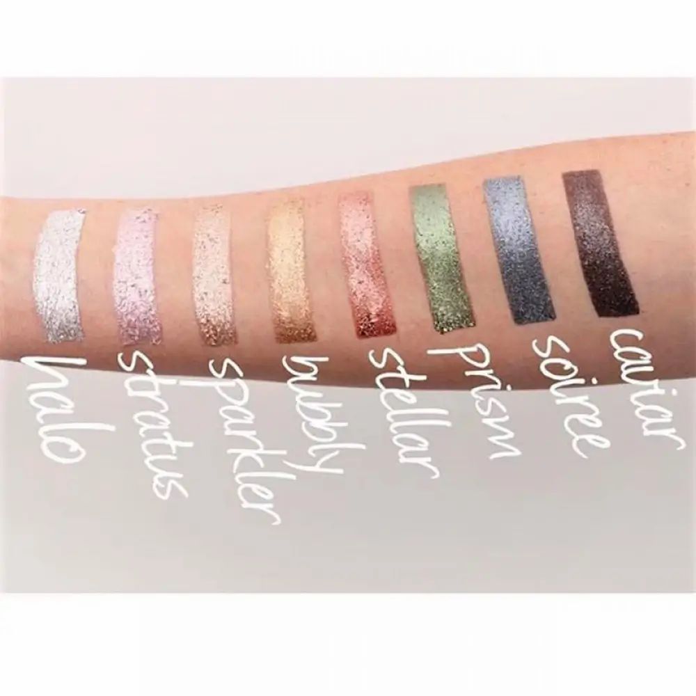 Braccio con 9 colori di ombretto glitterato. Nomi dei colori: Halo, Stratus, Sparkler, Bubbly, Stellar, Prism, Soiree, Caviar.
