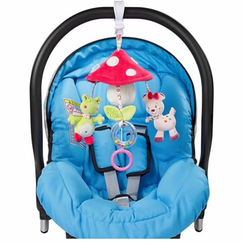 Mobile nel seggiolino auto. Mobile con fungo, cerbiatto e rana. Seggiolino auto con seduta blu e cinture di sicurezza.