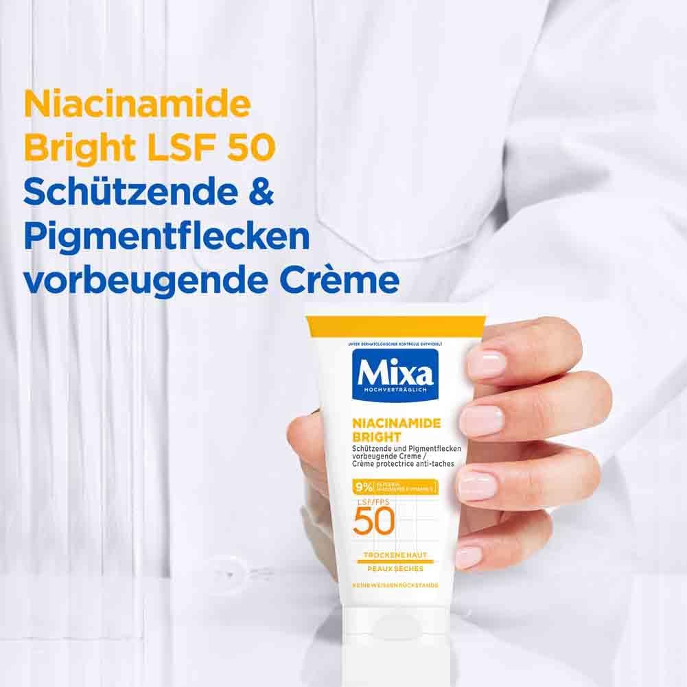 Persona tiene tubo Mixa Niacinamide Bright crema. Tappo giallo, SPF 50. Testo: Crema protettiva anti-macchie.