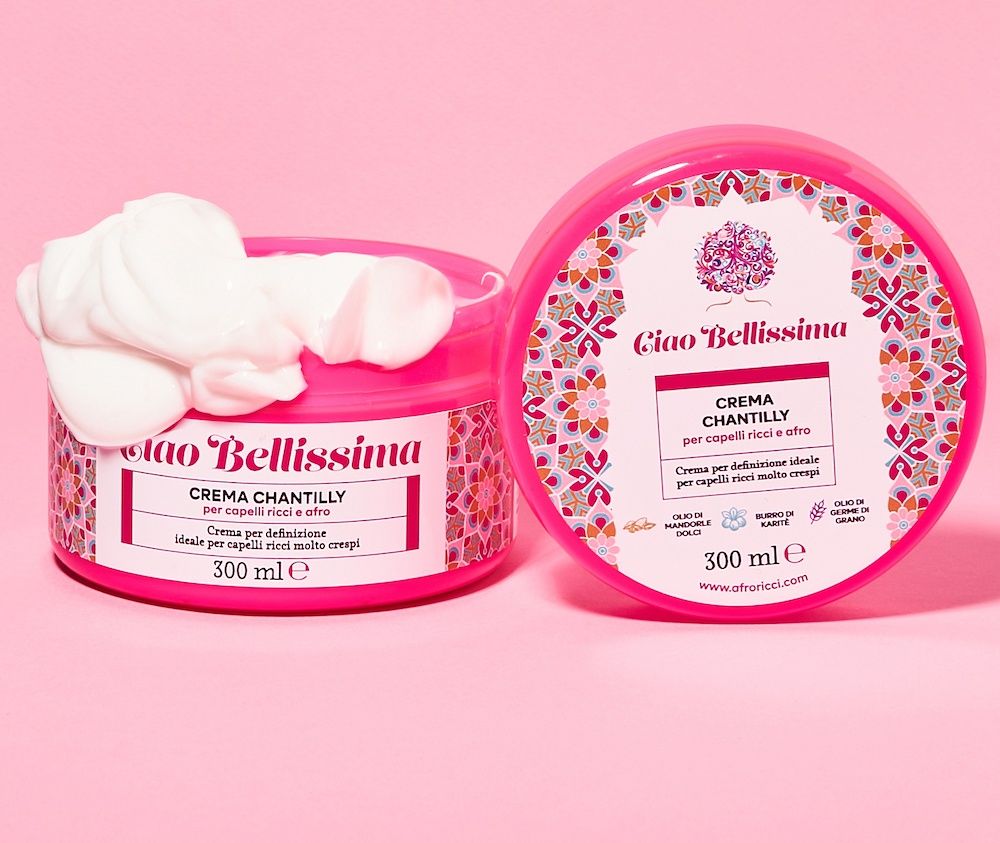 Due barattoli rosa con motivo floreale. Un barattolo aperto con crema bianca. Scritta: Ciao Bellissima, 300 ml.