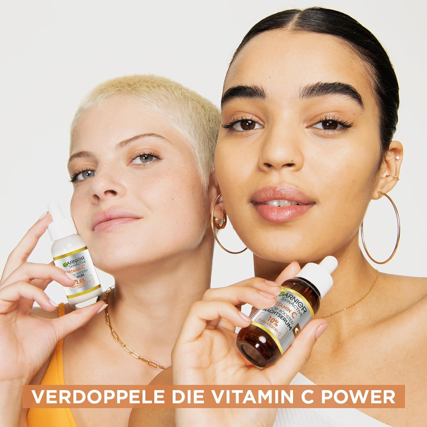 Due donne tengono flaconi di siero. Testo: Raddoppia il potere della vitamina C. Logo Garnier SkinActive.