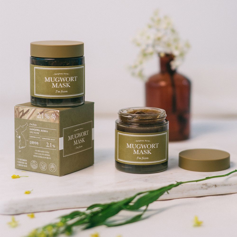 Due vasetti e una scatola di Mugwort Mask. Scritta: I'M FROM Mugwort Mask. Vasetti marroni, coperchi ed etichette verdi.