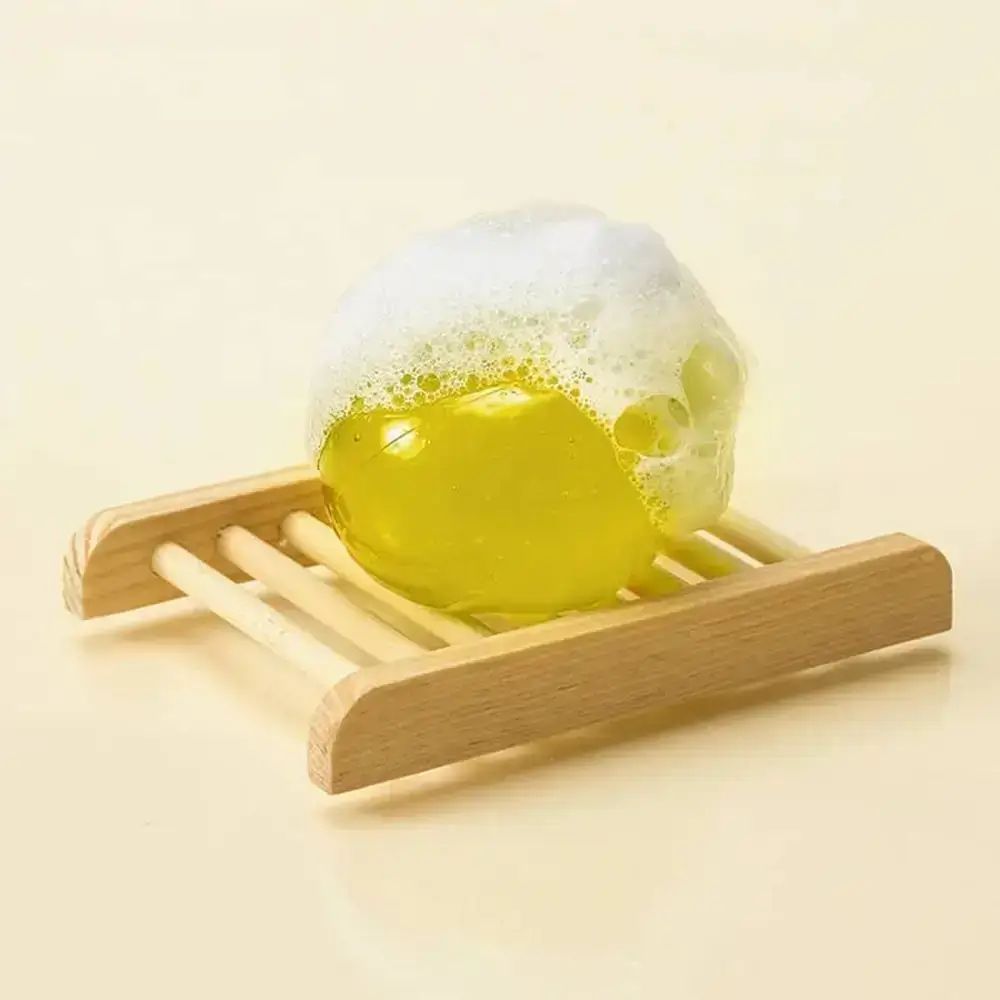 Sfera gialla con schiuma su griglia di legno.