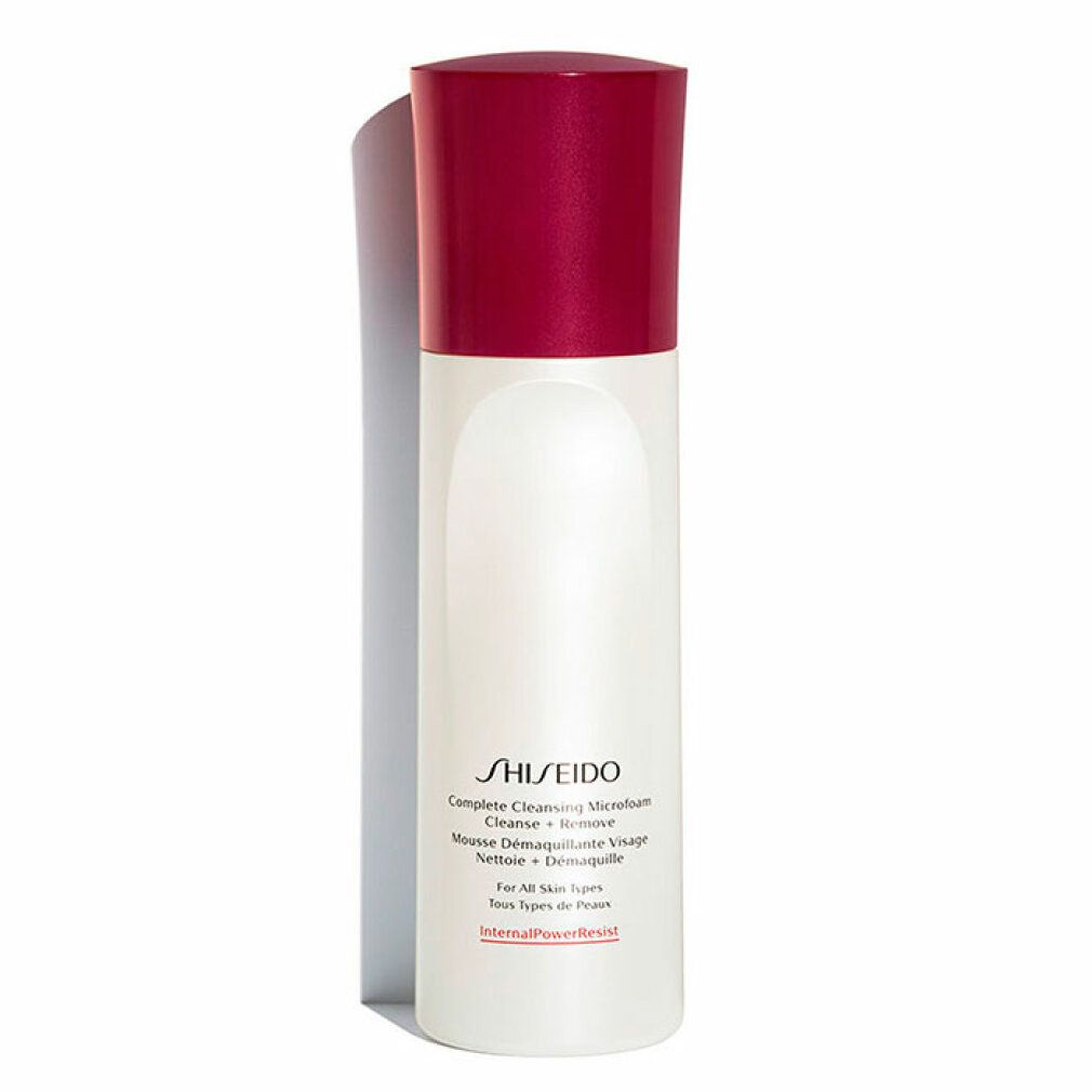 Flacone bianco e rosso Shiseido Microfoam detergente. Forma cilindrica, tappo rosso. Testo: Complete Cleansing Microfoam.