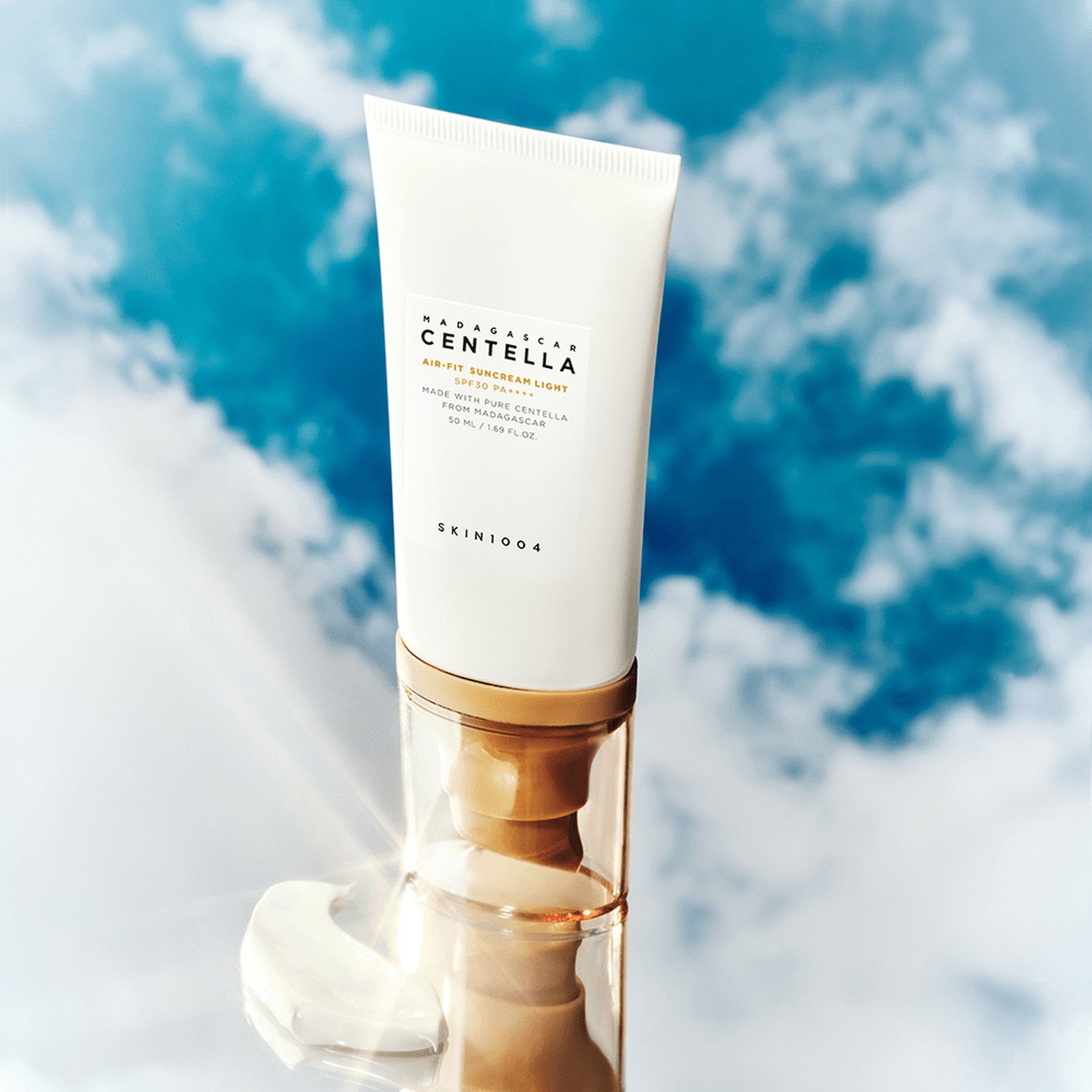 Tubo SKIN1004 Air-Fit Suncream Light SPF30 su uno specchio davanti a uno sfondo di cielo.