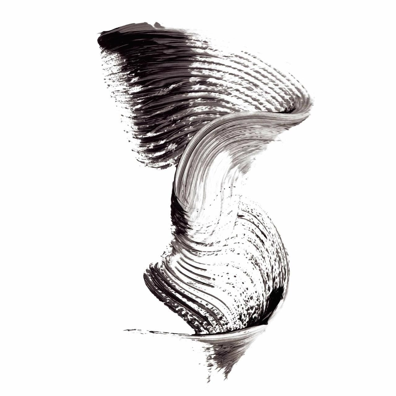 Applicazione di mascara nero su sfondo bianco. La texture è ondulata.