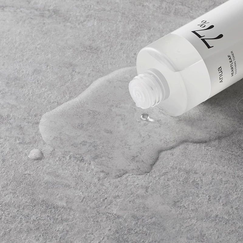 Liquido trasparente che fuoriesce da un flacone bianco. Scritte: Anua, 77%, Heartleaf Soothing Toner.