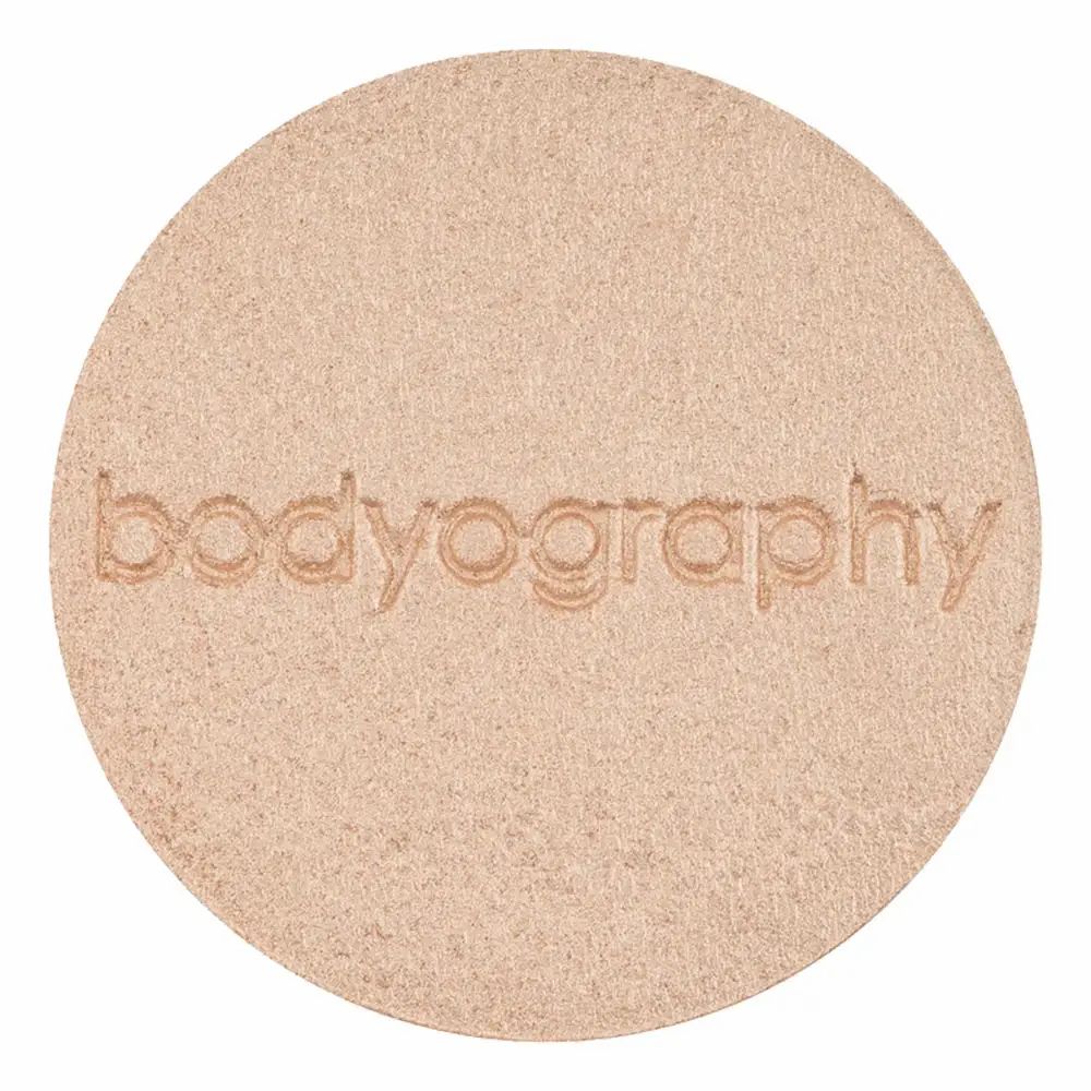 Highlighter pressato rotondo. Colore beige dorato. Scritta in rilievo: bodyography.