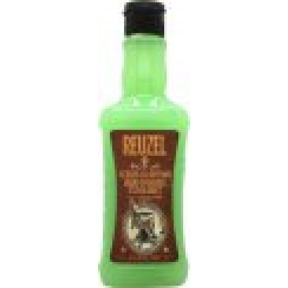 Flacone verde con tappo nero. Etichetta marrone con "REUZEL SCRUB SHAMPOO" e logo poltrona da barbiere.