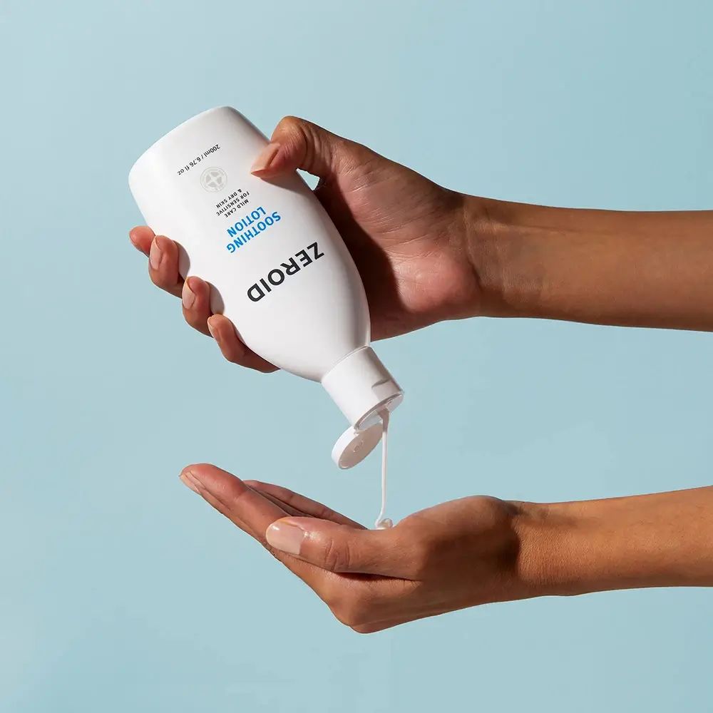 Flacone bianco ZEROID Soothing Lotion, contenuto versato in mano. Logo e testo blu. Contiene 200ml/6.76 fl oz.