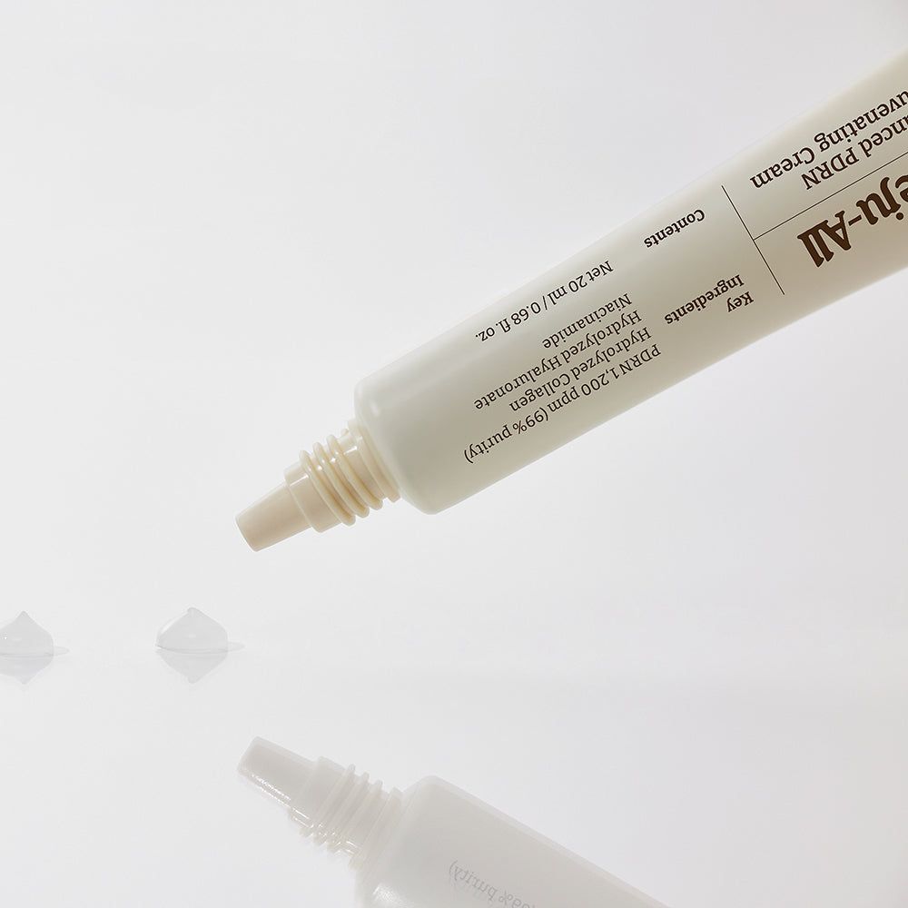 Un tubo di crema rivitalizzante Dr. Reju-All Advanced PDRN, da cui fuoriescono tre piccole gocce di crema.