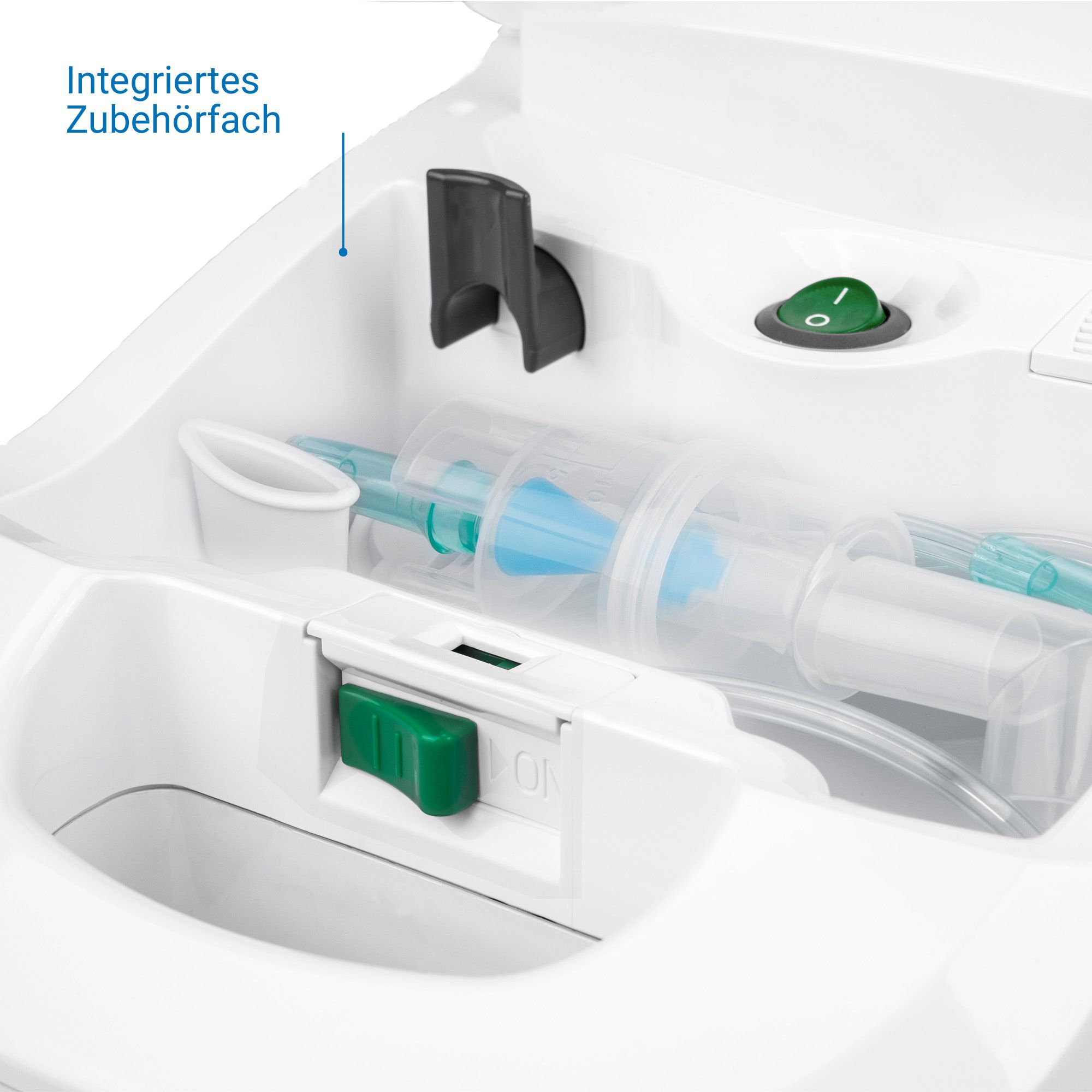 Vista dettagliata dell'inalatore Medisana: vano accessori integrato con maschere, tubi e accessori. Pulsante di accensione verde.
