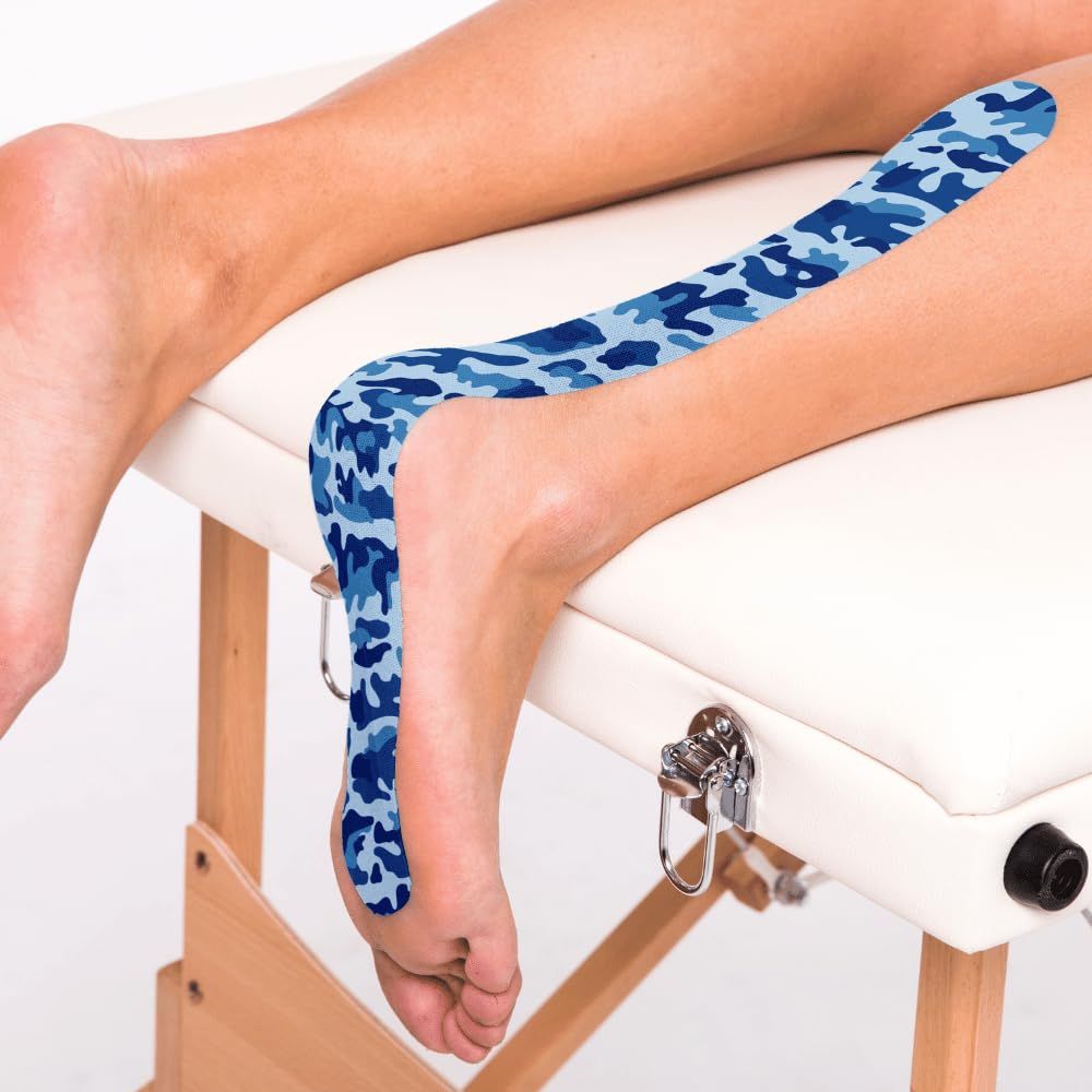 Gamba con CureTape sul piede. Motivo mimetico blu. Letto sullo sfondo.