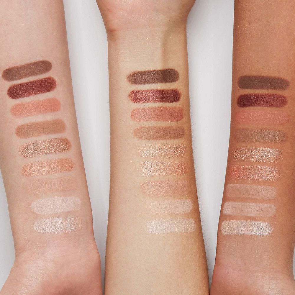 Braccia con campioni di 10 colori di ombretto rosa e marrone. Diverse tonalità della pelle.