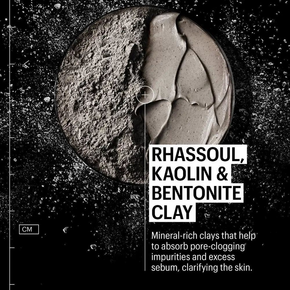 Primo piano di una sostanza grigia. Testo: Rhassoul, Kaolino & Bentonite Clay. Aiuta ad assorbire il sebo in eccesso e a chiarire la pelle.
