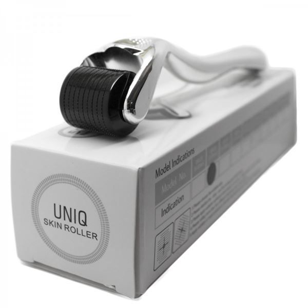 Derma roller con manico argentato e testina nera sulla confezione del prodotto.