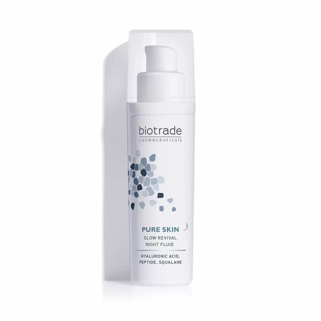 Flacone bianco con pompa e tappo trasparente. Scritta: Biotrade, Pure Skin Glow Revival Night Fluid. Contiene acido ialuronico, peptide, squalano.