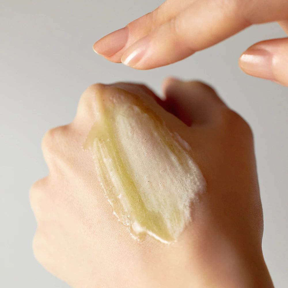 Mano con sostanza gelatinosa. Un'altra mano tocca la sostanza. Nessuna denominazione del prodotto visibile.