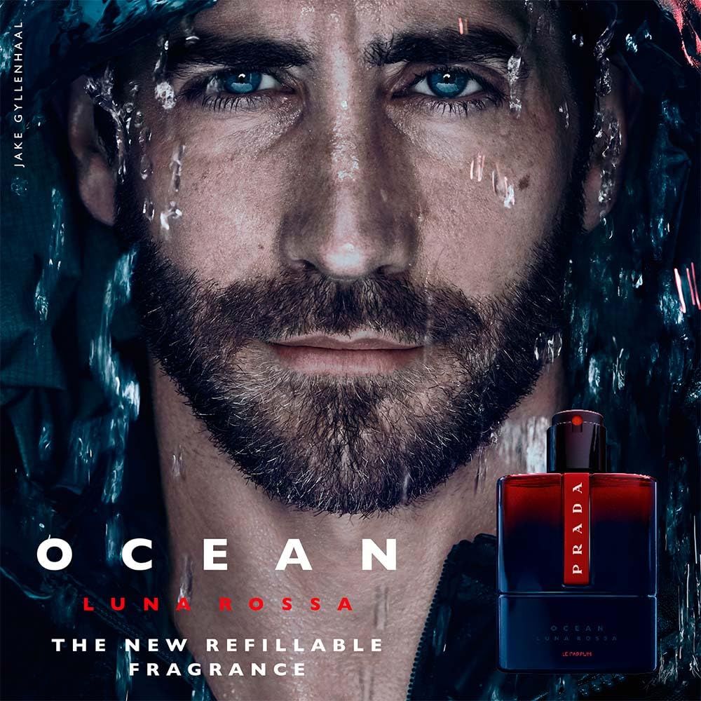 Volto di uomo con barba e acqua. Flacone: blu scuro, rosso, logo Prada. Testo: OCEAN LUNA ROSSA, THE NEW REFILLABLE FRAGRANCE.