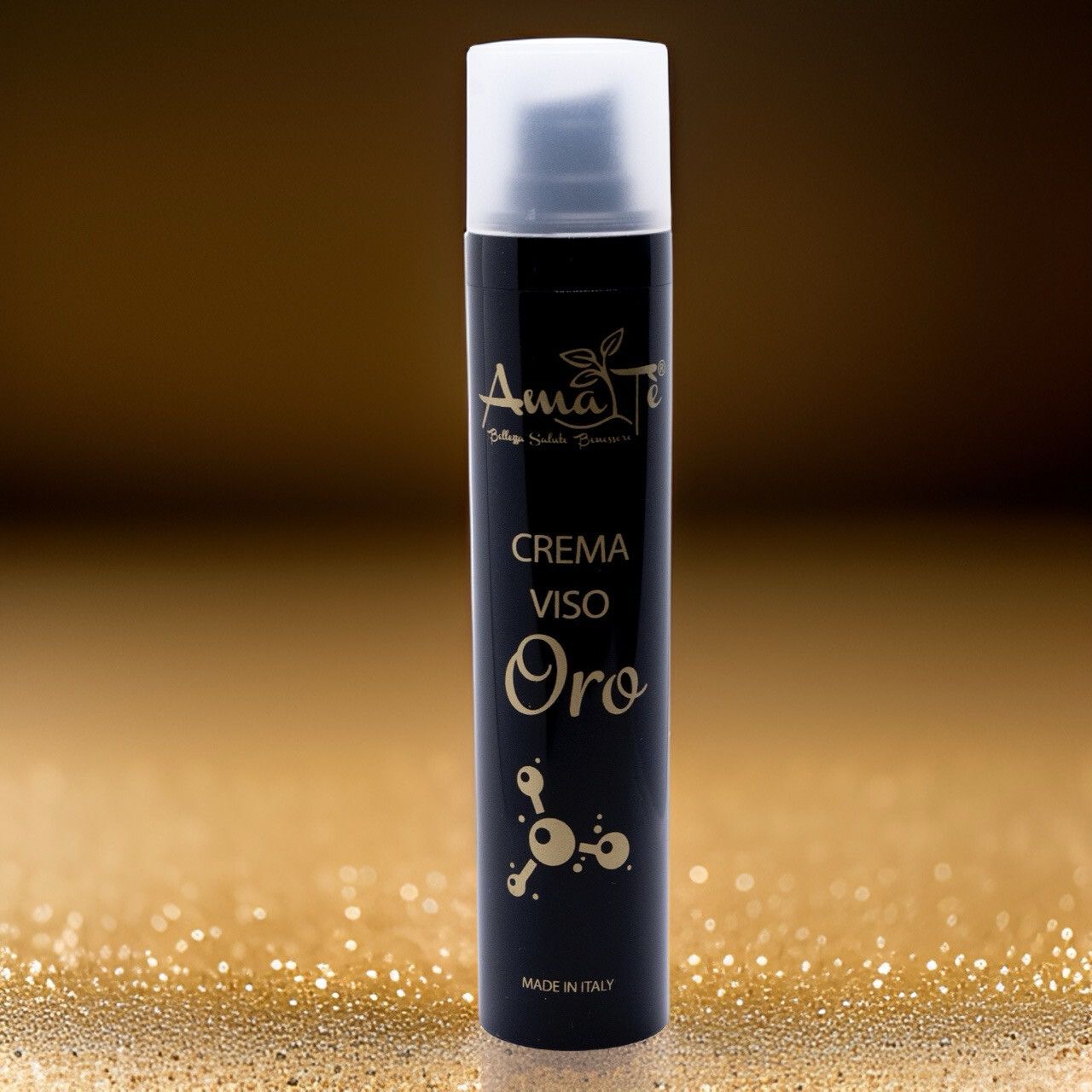 Flacone nero con testo dorato. Scritta: Amatè Crema Viso Oro. Made in Italy. Erogatore bianco. Sfondo glitter oro.