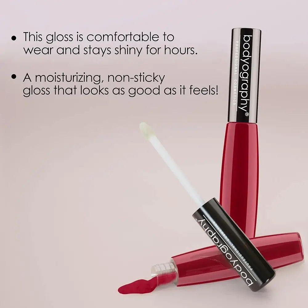 Due tubetti di lucidalabbra, uno con applicatore. BODYOGRAPHY è scritto sul tubetto. Testo: 'This gloss is comfortable to wear and stays shiny for hours.'