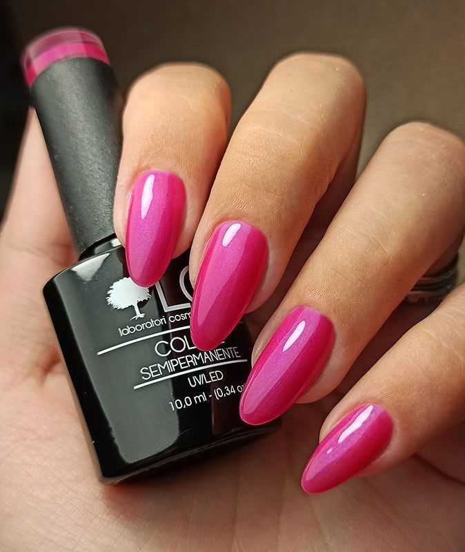 Mano con unghie smaltate e flacone smalto. Colore Fucsia Marrakech. Scritta: LCI, Colore Semipermanente.