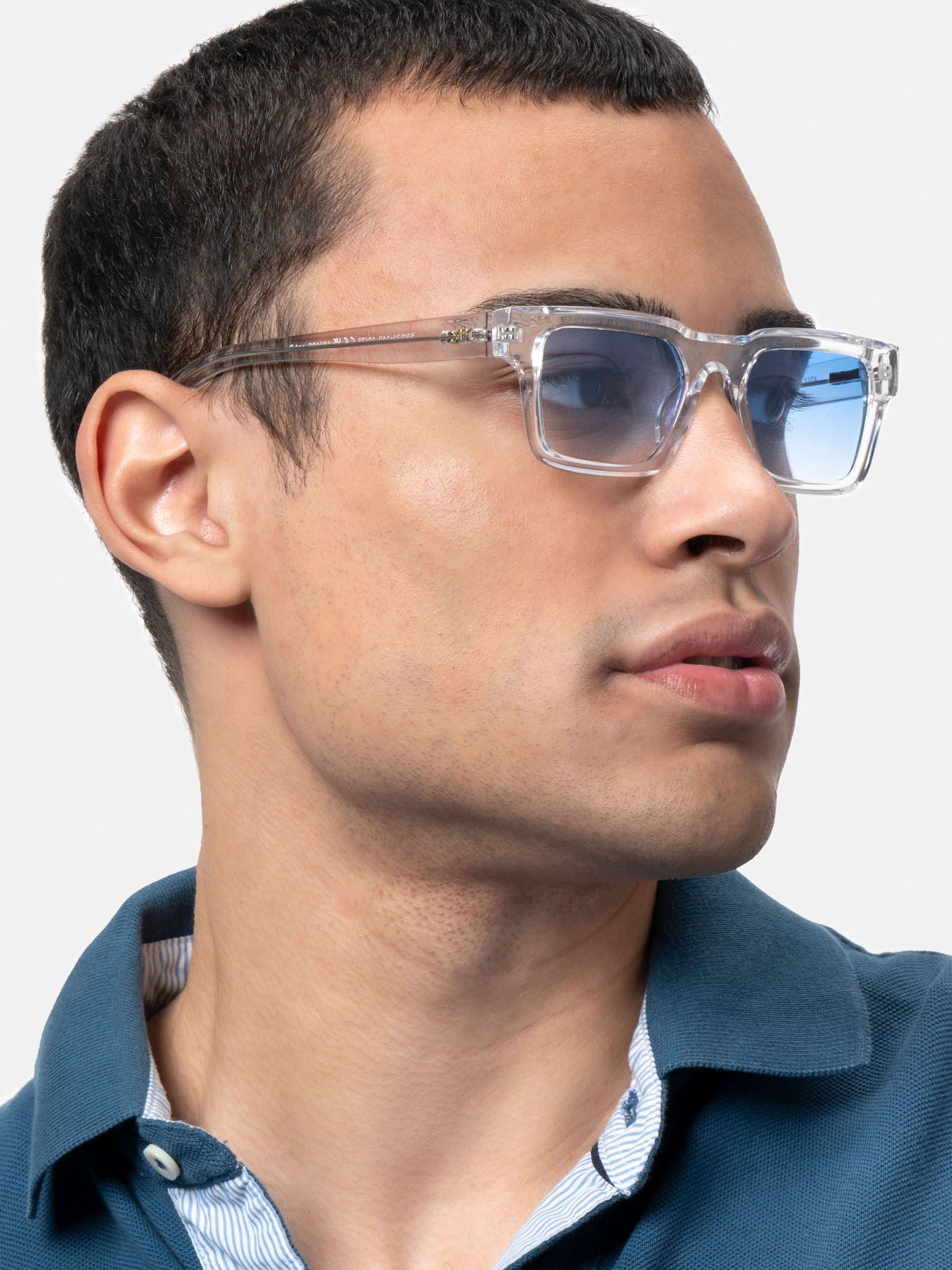 Uomo con occhiali da sole trasparenti con lenti blu, vista laterale. X Frame Therapy. Forma rettangolare.