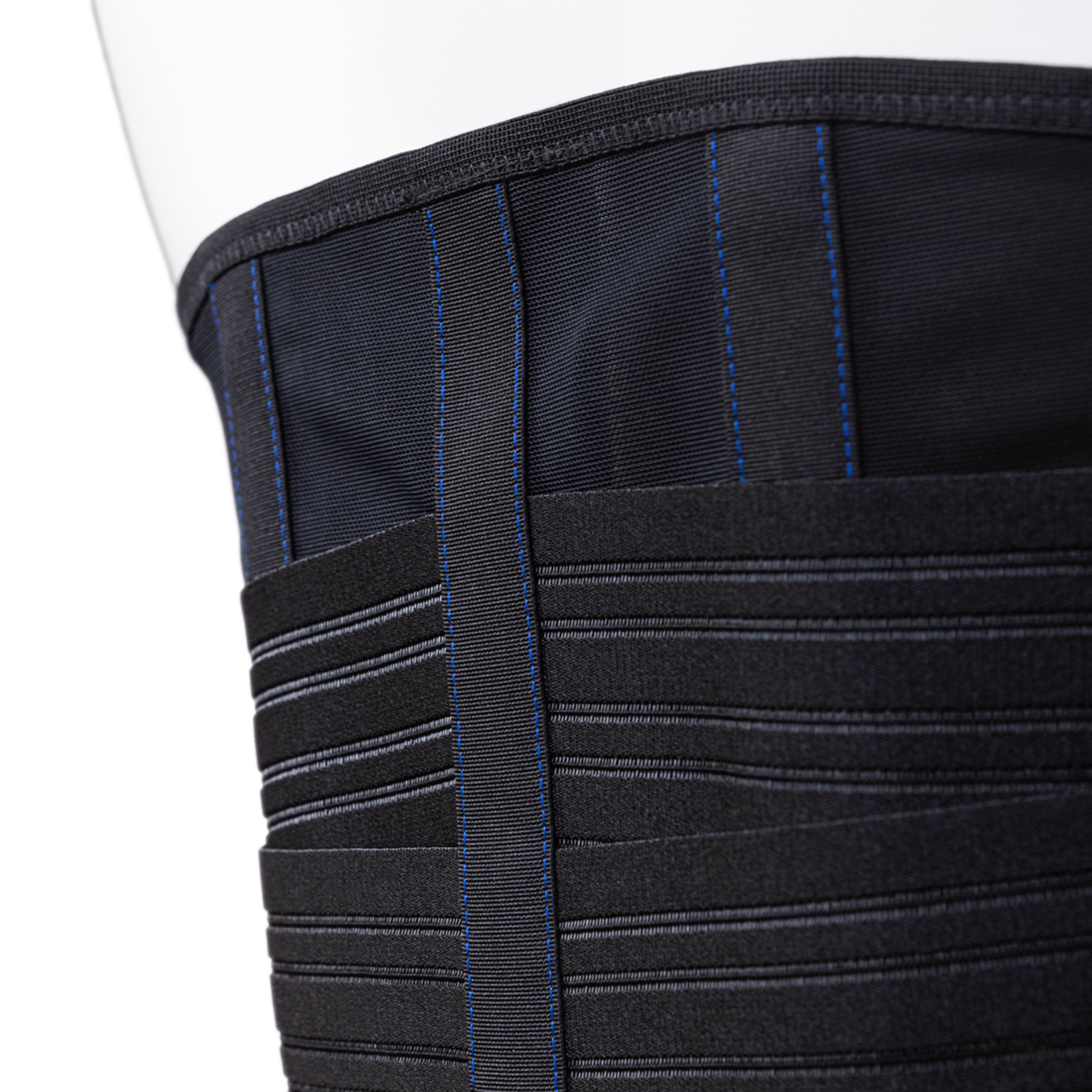 Primo piano di una fascia lombare nera. Cuciture blu e fasce orizzontali visibili.