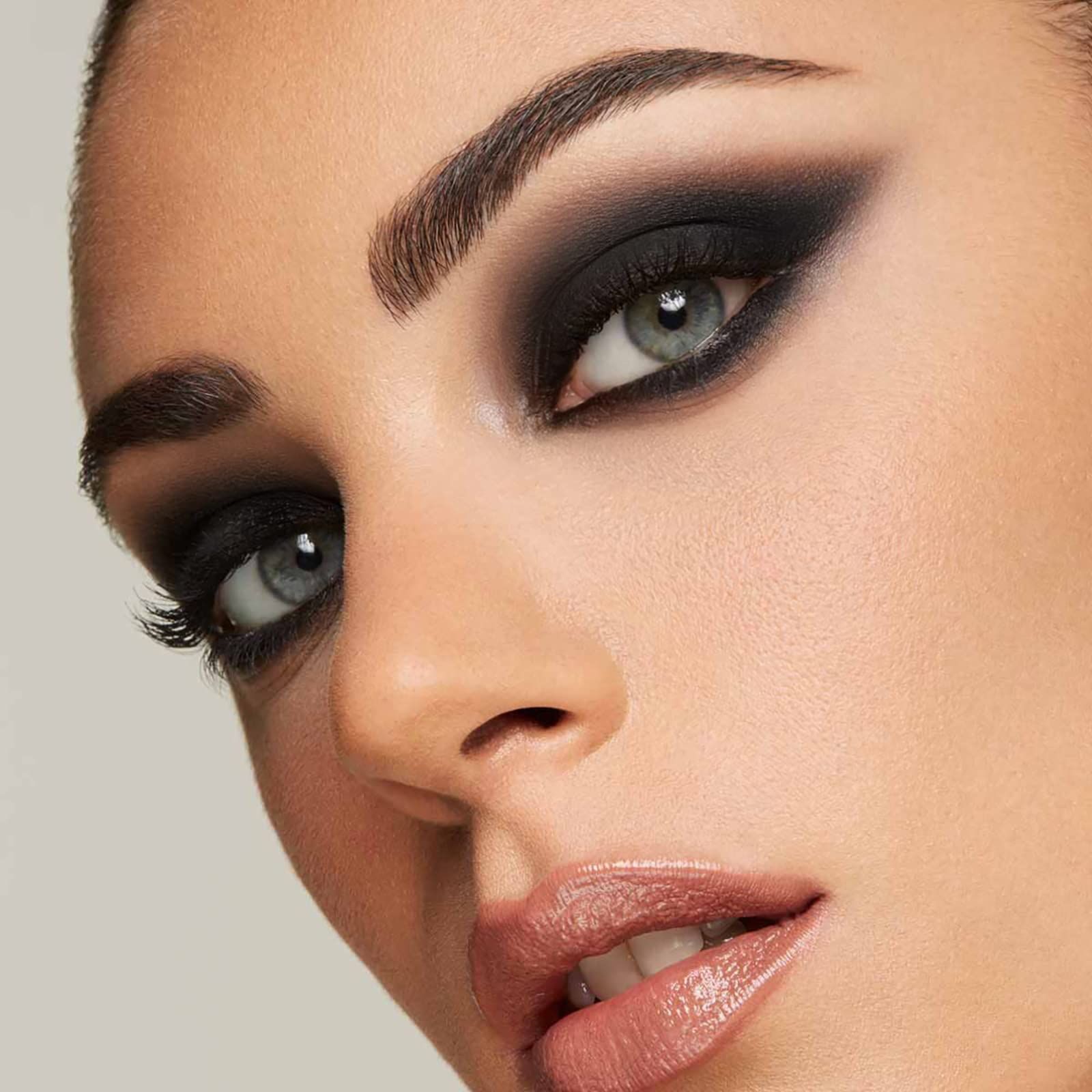 Primo piano di un viso con occhi pesantemente truccati. Ombretto nero. Rossetto. Tonalità della pelle.