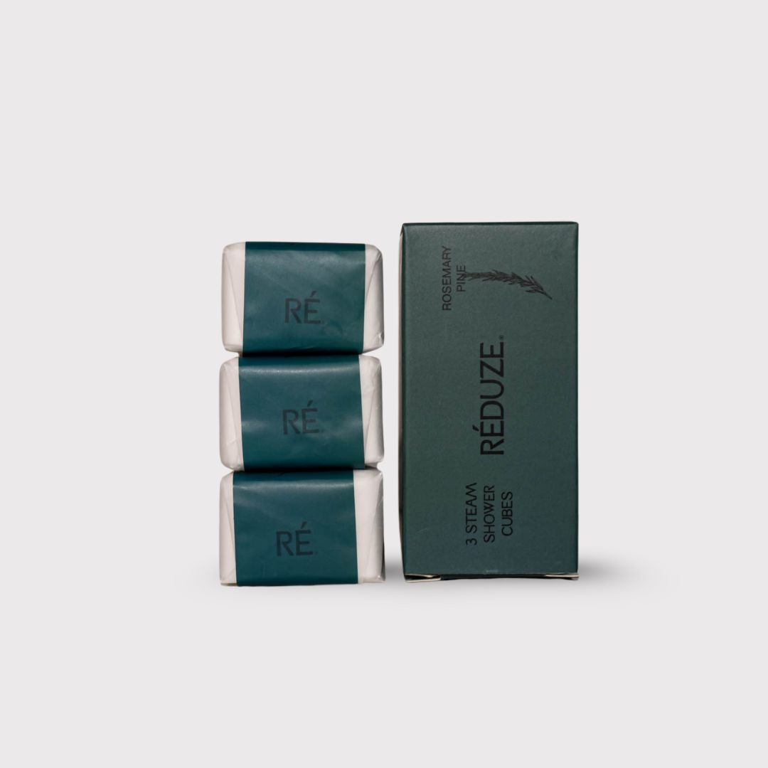 Tre cubetti doccia avvolti in carta verde, accanto a una scatola verde con il logo RÉDUZE.