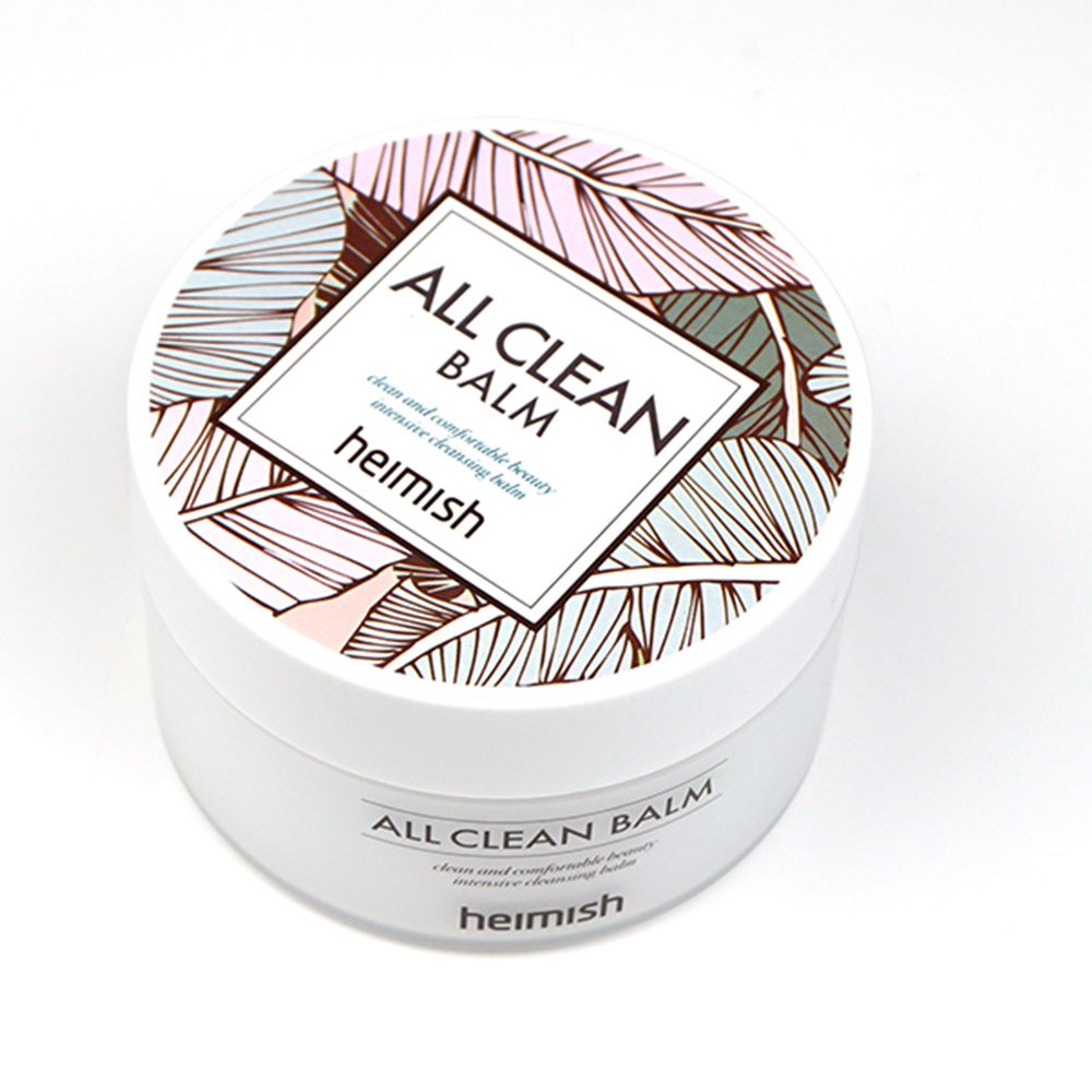 Heimish All Clean Balm in un barattolo bianco con coperchio a motivo di foglie. Il barattolo è appoggiato su un asciugamano.