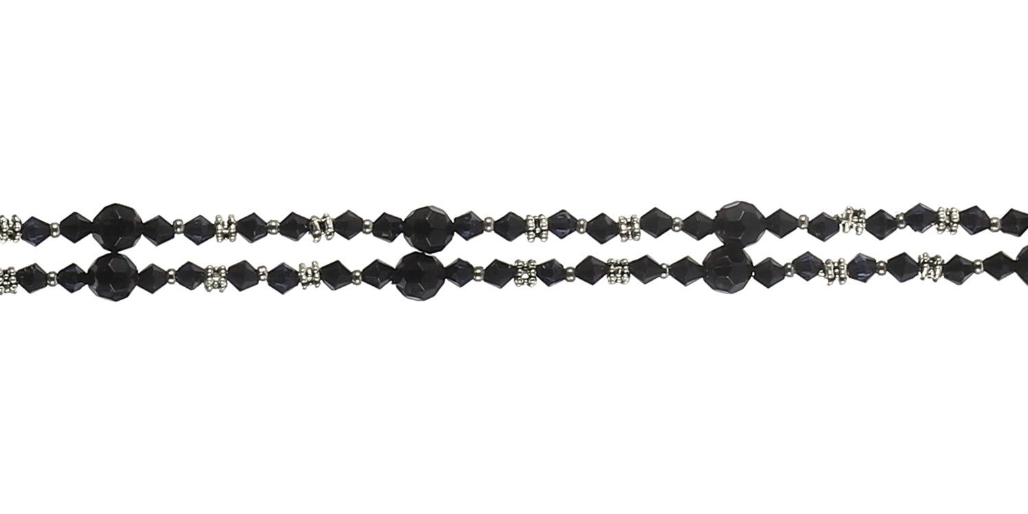 Primo piano della catenina per occhiali. Perle e cristalli neri. Connettori metallici.