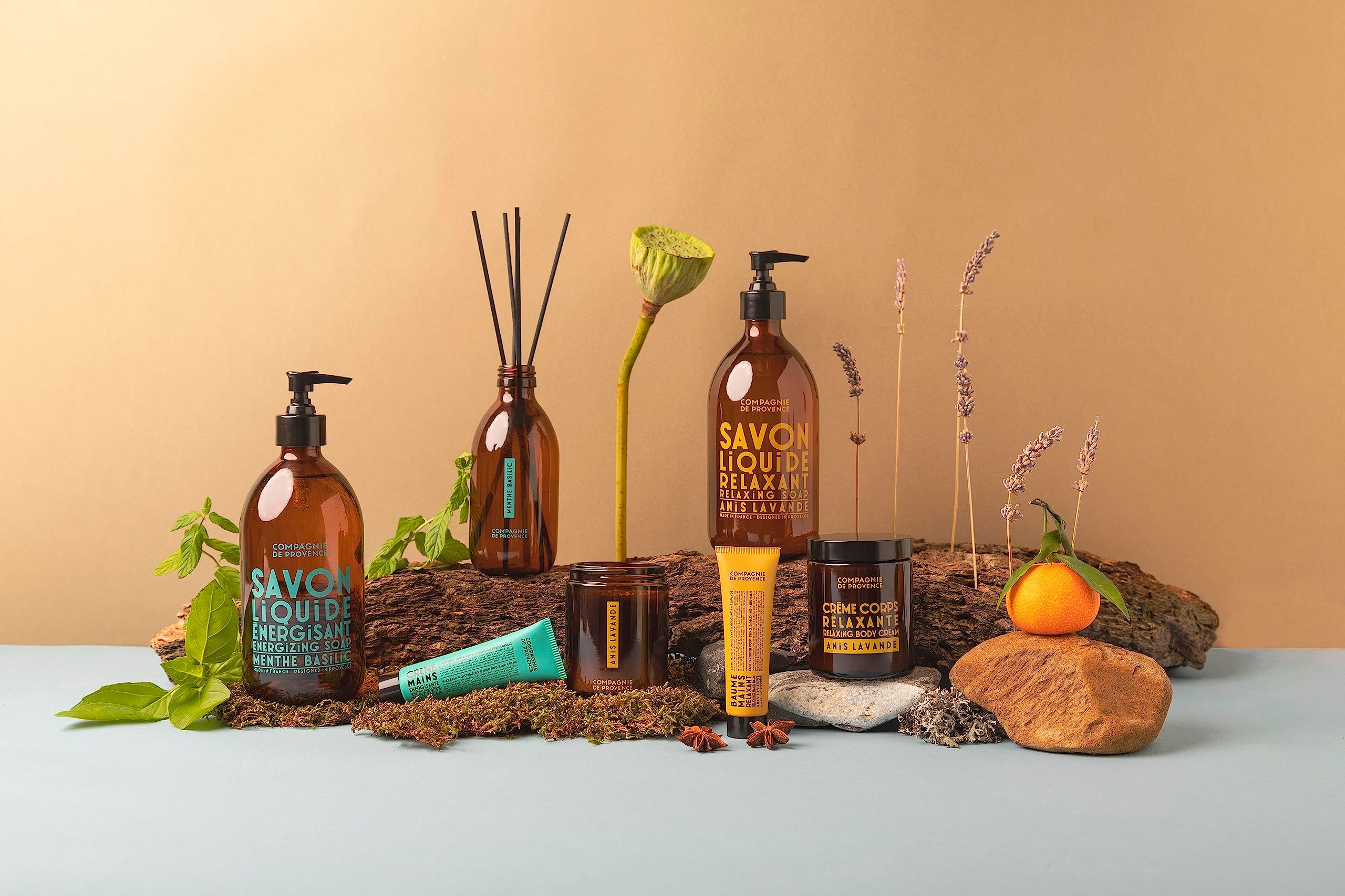 Diversi prodotti: flaconi, vasetti, candele e un tubetto. Scritta: Savon Liquide Relaxant. Marchio Compagnie de Provence.