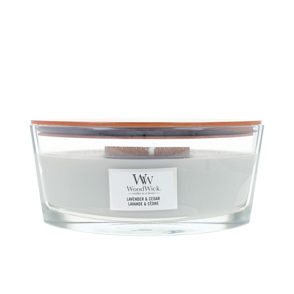 Candela con coperchio in legno. Scritta: WoodWick, Lavanda & Cedro. Contenitore in vetro, cera grigio chiaro.