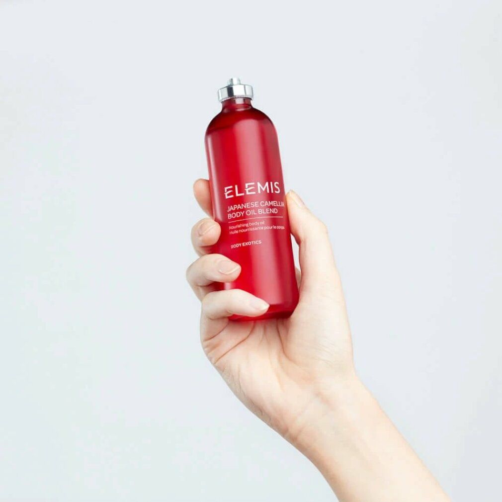 Mano che tiene un flacone rosso con tappo argentato. Scritta: Elemis Japanese Camellia Body Oil Blend. Olio corpo.