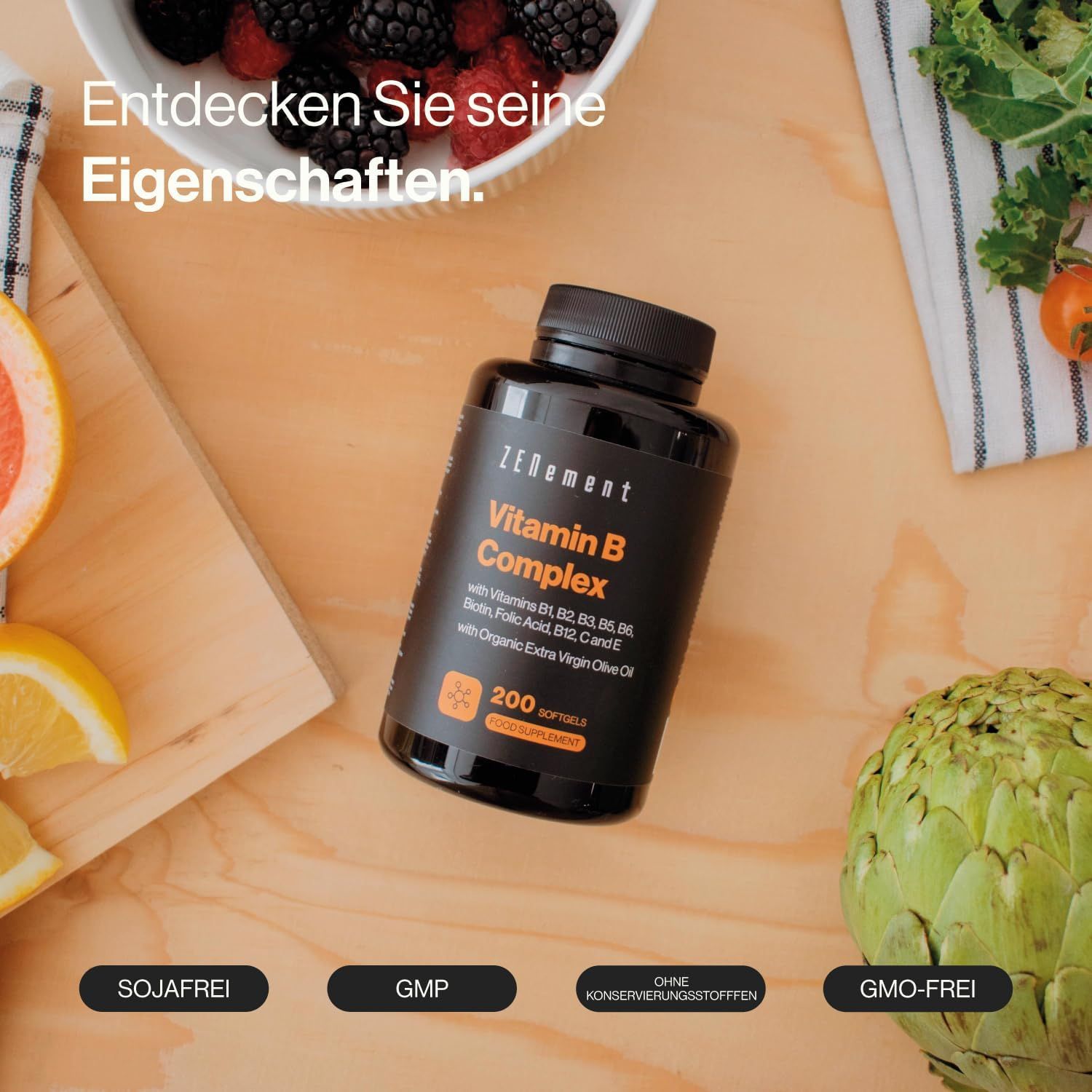 Flacone nero di capsule Zenement Vitamina B Complex. Scritta: 200 capsule. Frutta e verdura su un tavolo di legno.