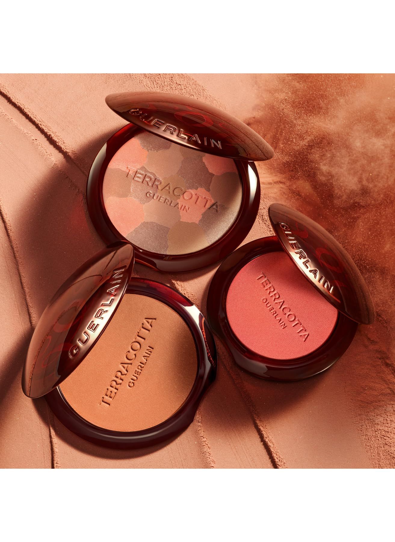 Tre confezioni di cipria blush. Scritta: Terracotta Guerlain. Coperchi aperti. Diverse tonalità.