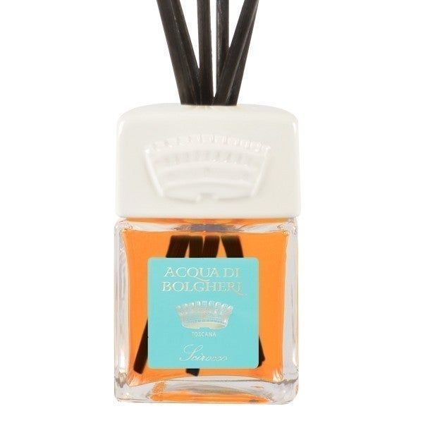 Flacone di profumo per ambienti con bastoncini neri. Flacone di vetro rettangolare con coperchio bianco ed etichetta blu.