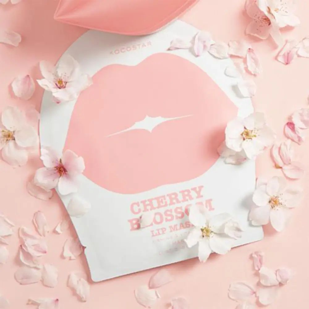 Confezione con maschera per labbra e fiori di ciliegio. Forma di labbra rosa su sfondo bianco. Testo: Cherry Blossom Lip Mask.