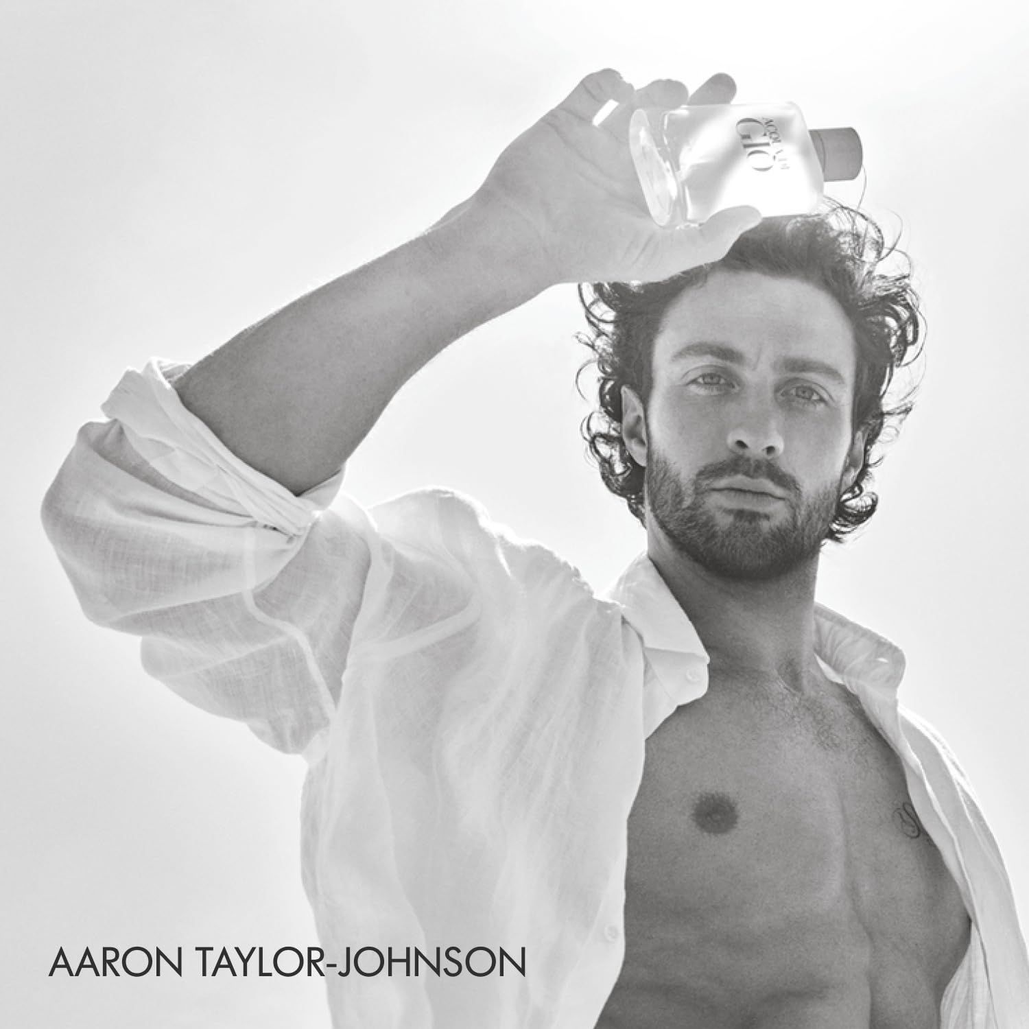 Uomo tiene flacone sopra la testa. Testo: Aaron Taylor-Johnson. Flacone: Acqua di Giò Profondo.