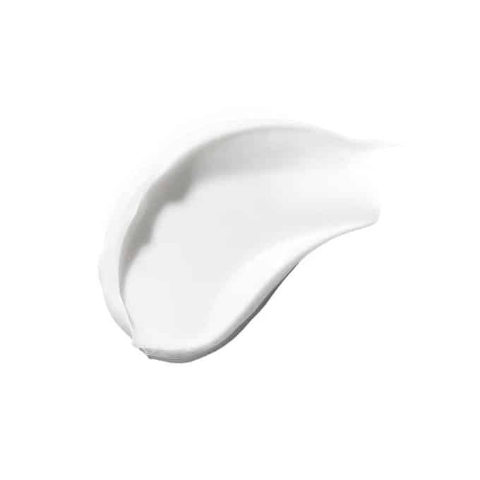 Macchia di crema bianca su sfondo bianco. Consistenza visibile.