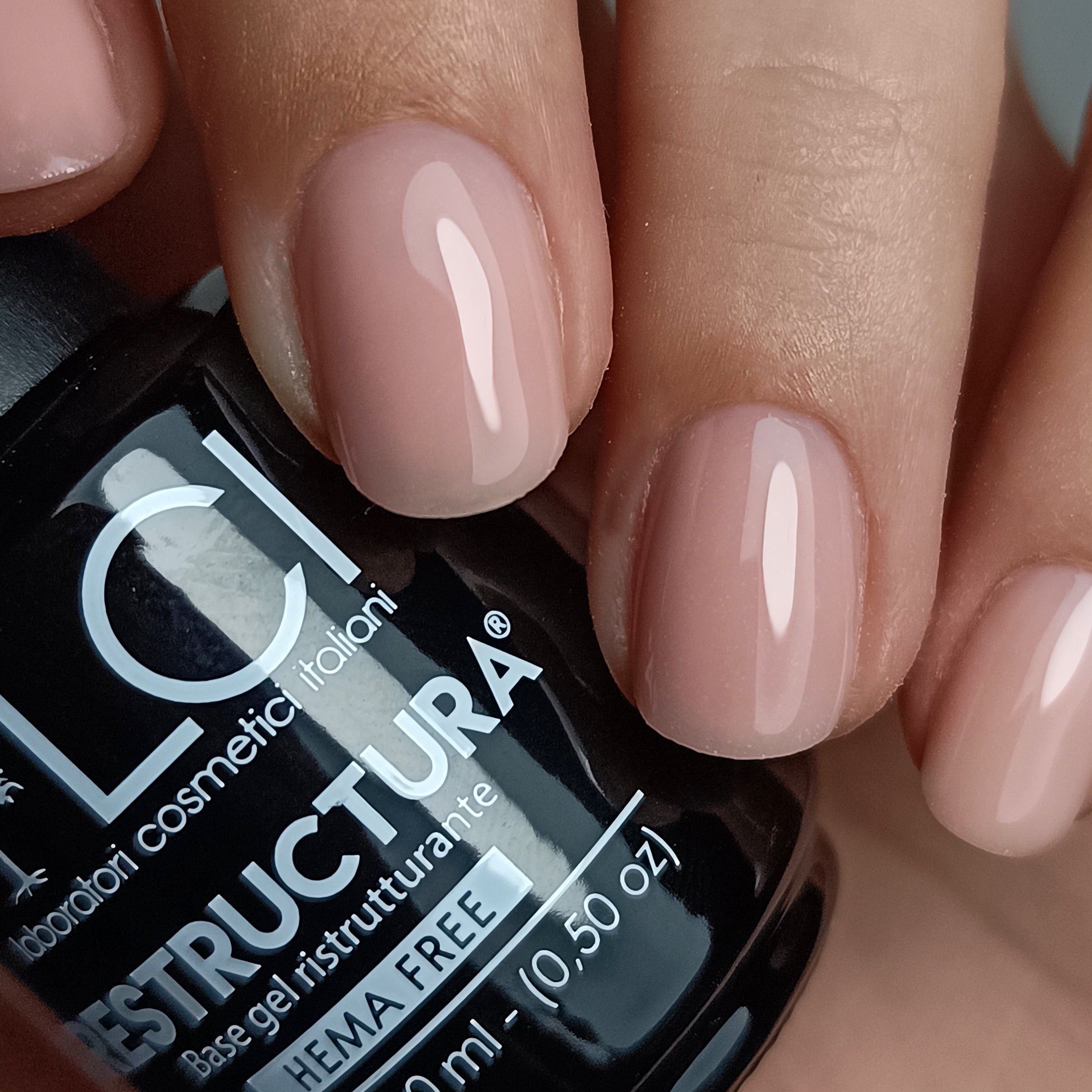 Smalto applicato sulle unghie. Flacone con stampa parzialmente visibile.