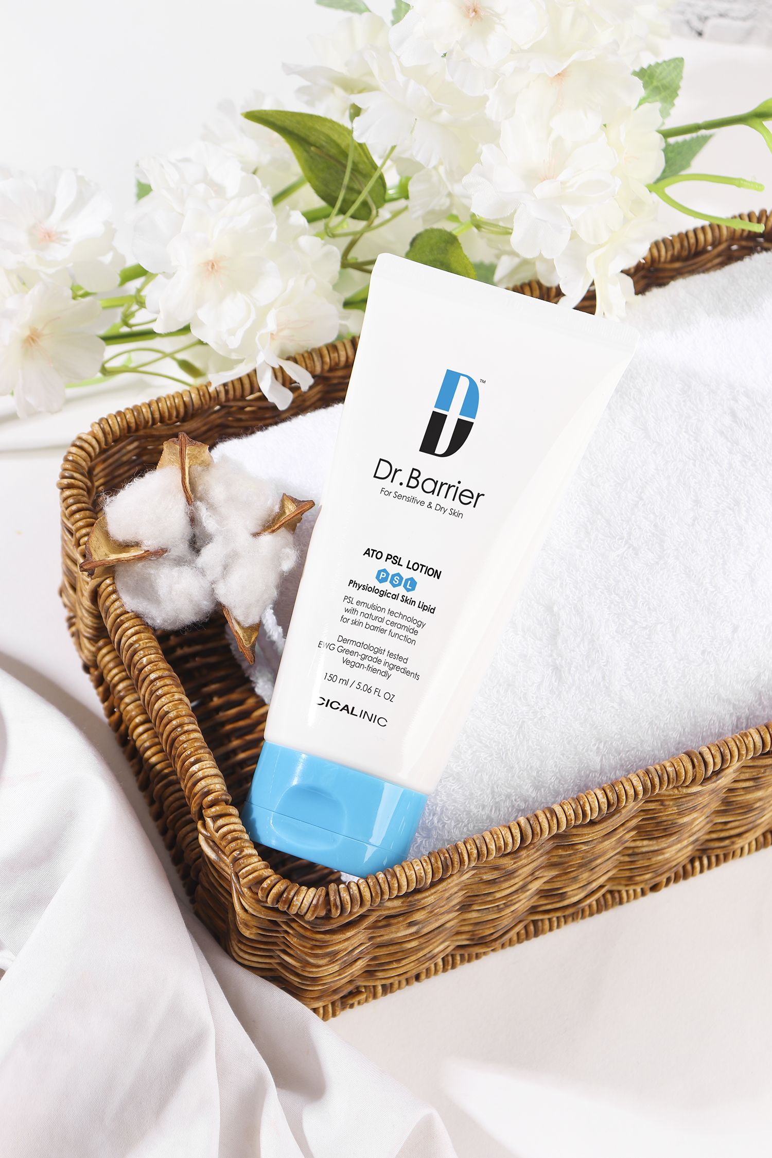 Tubo bianco con tappo blu in un cestino. Scritta: Dr.Barrier ATO PSL Lotion. Per pelli sensibili e secche.