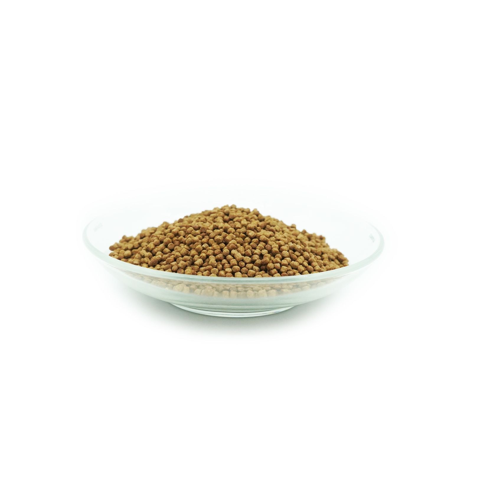 Mangime per carpe koi marrone in una ciotola di vetro. Pellet rotondi. Su sfondo bianco.